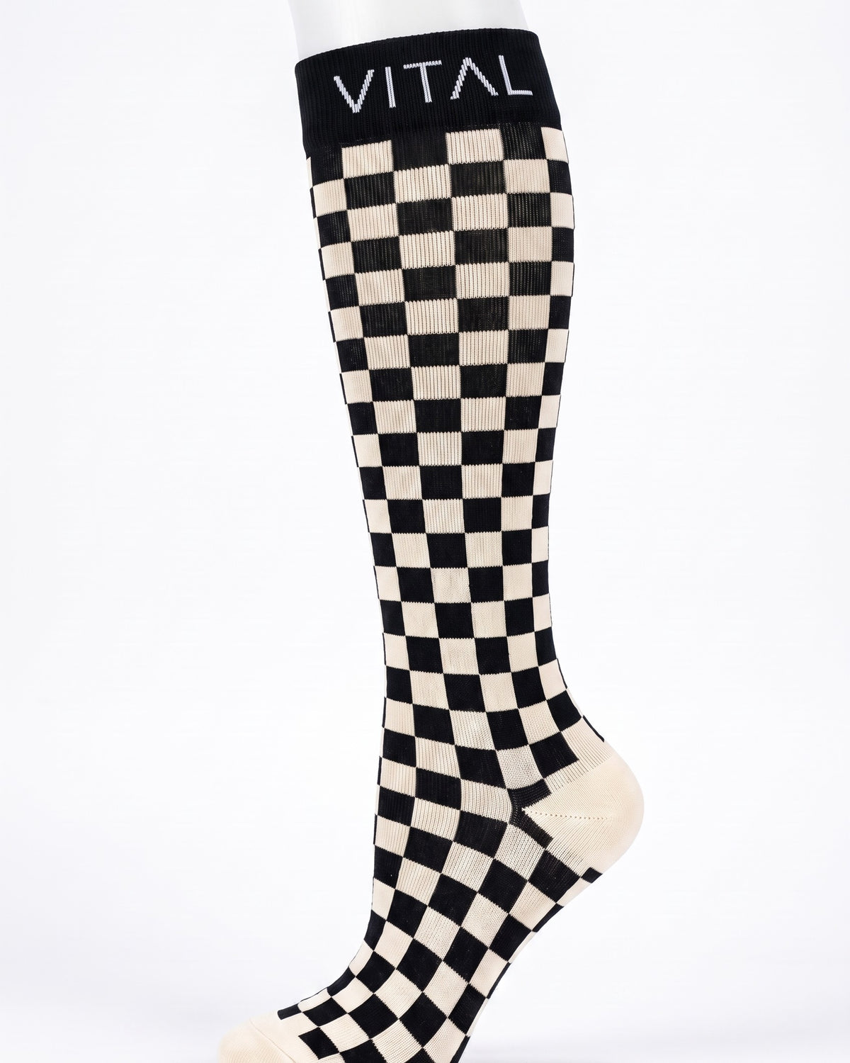 Checker knee-high compression sock on a white leg form, black and cream squares, studio shot
