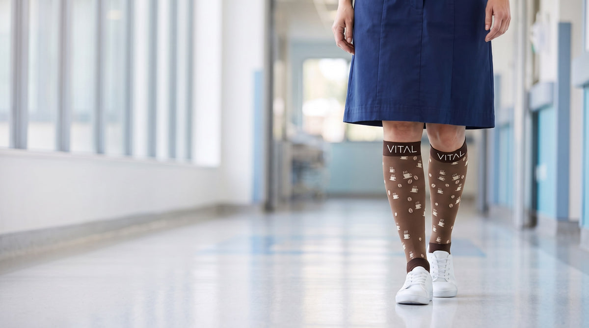 Espresso knee-high compression socks with a navy dress, front view in a long window-lined corridor